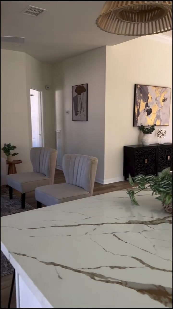 Finished open kitchen with a stone island, white cabinetry, and connected dining space