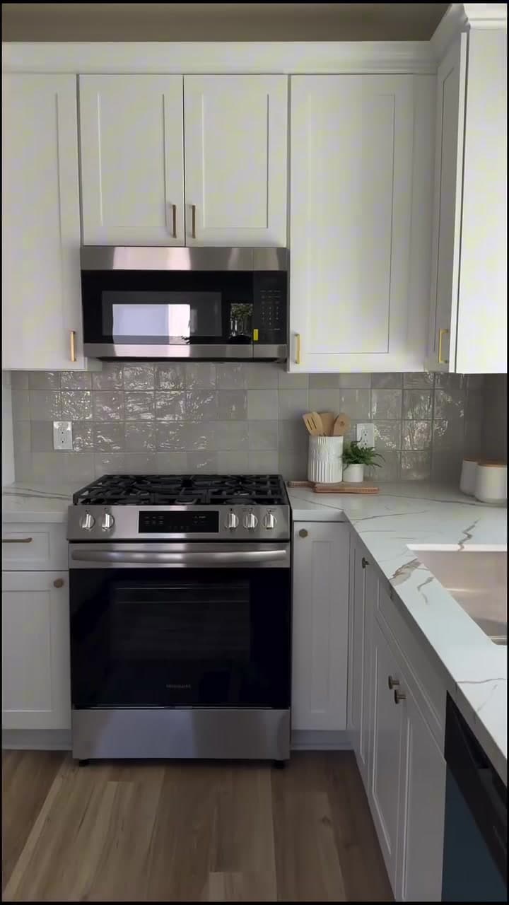 Finished kitchen range wall with white cabinetry and backsplash