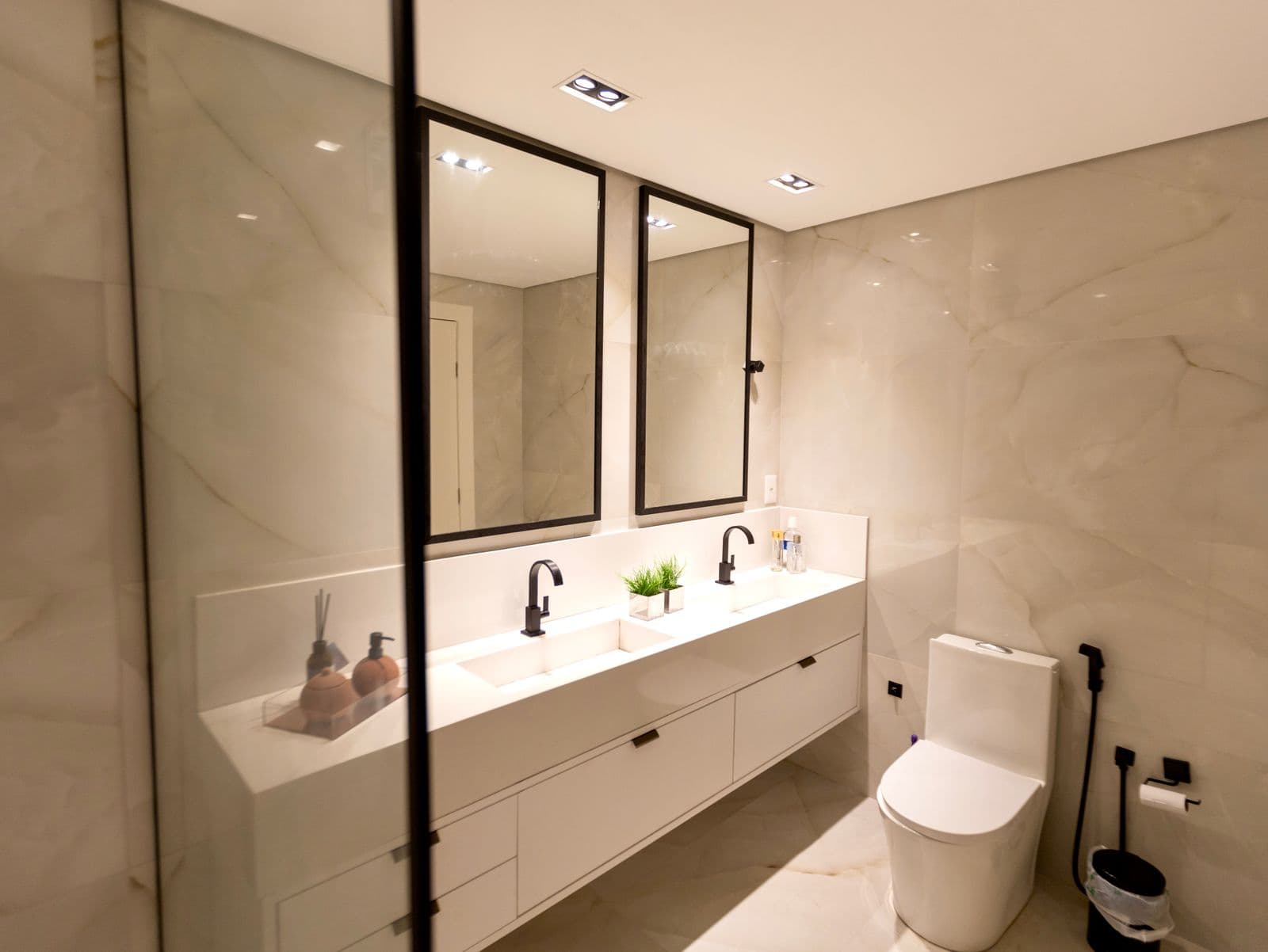Finished bathroom design inspiration with a long double vanity, black-framed mirrors, and large-format wall tile