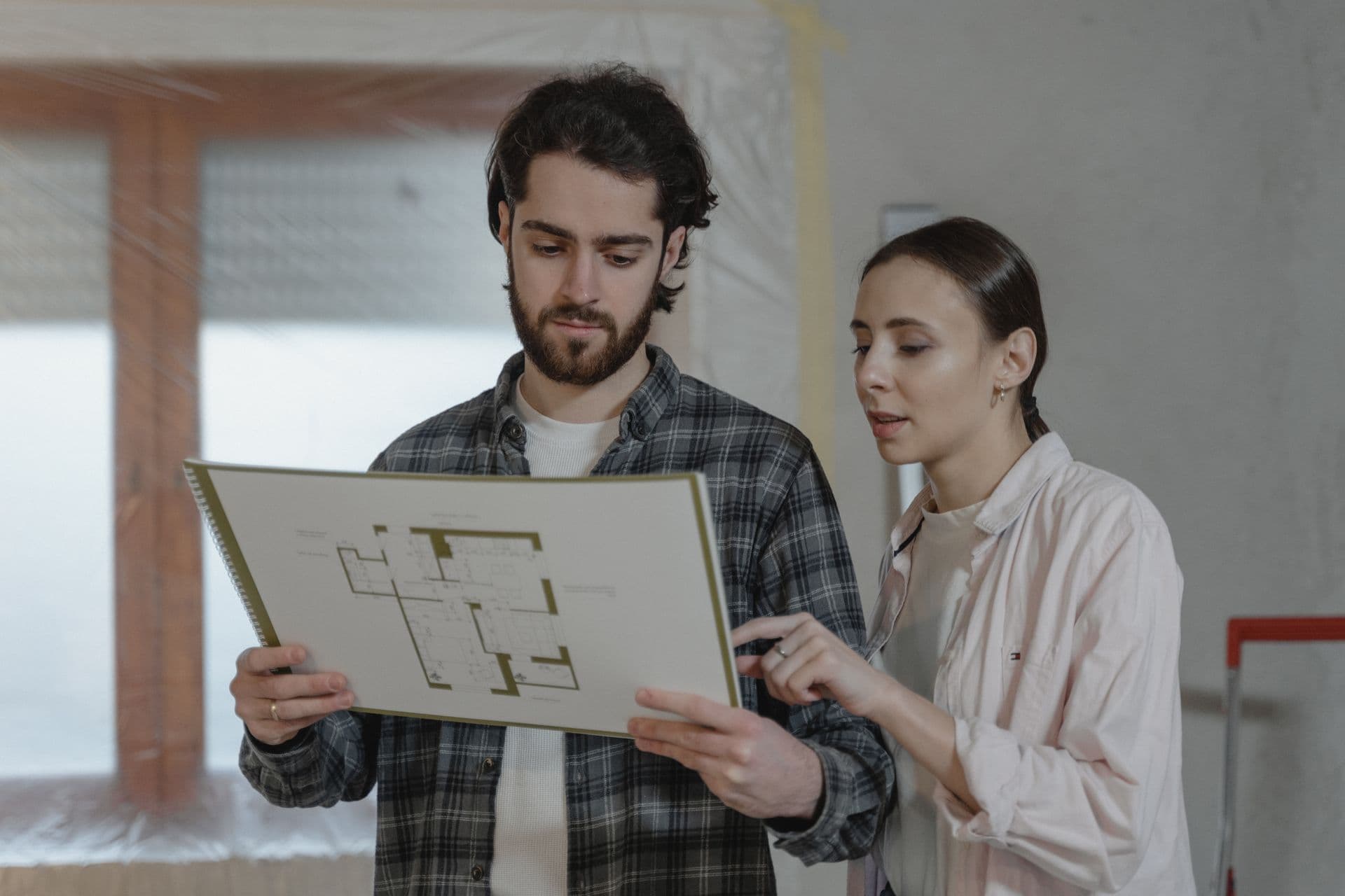 Homeowners reviewing a floor plan during a remodeling planning conversation
