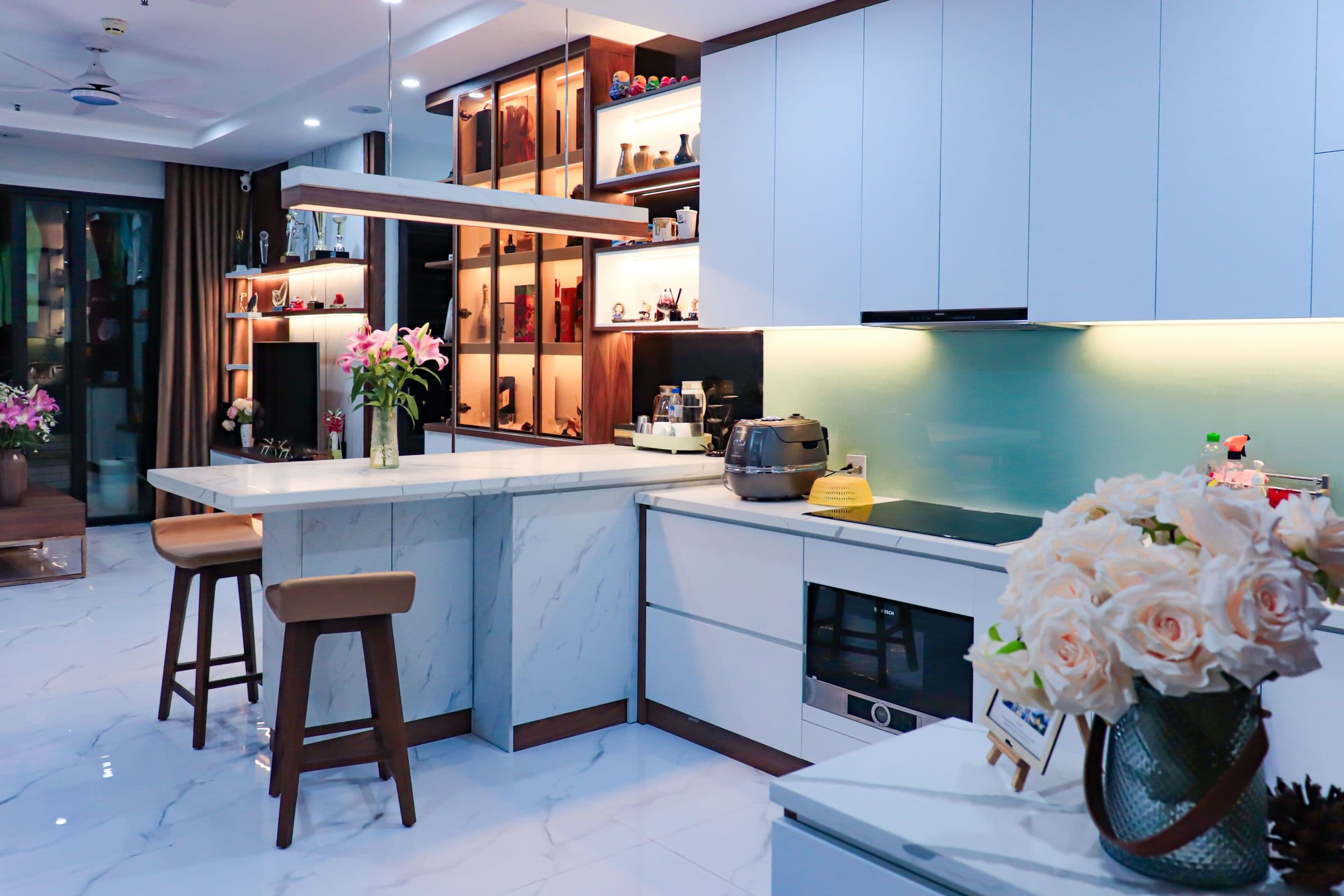 High-end kitchen design inspiration with blue and white cabinetry, marble island, and decorative lighting