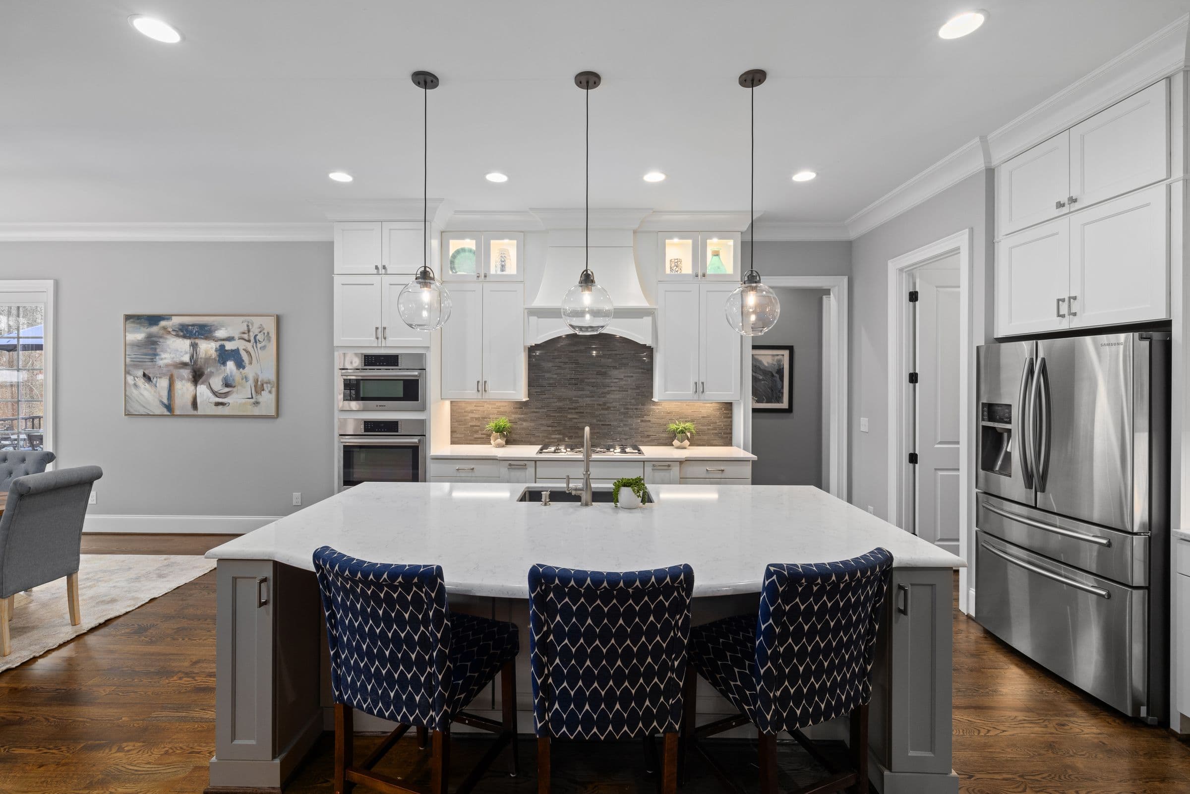 Bright kitchen design inspiration with white cabinets, a large island, and pendant lighting